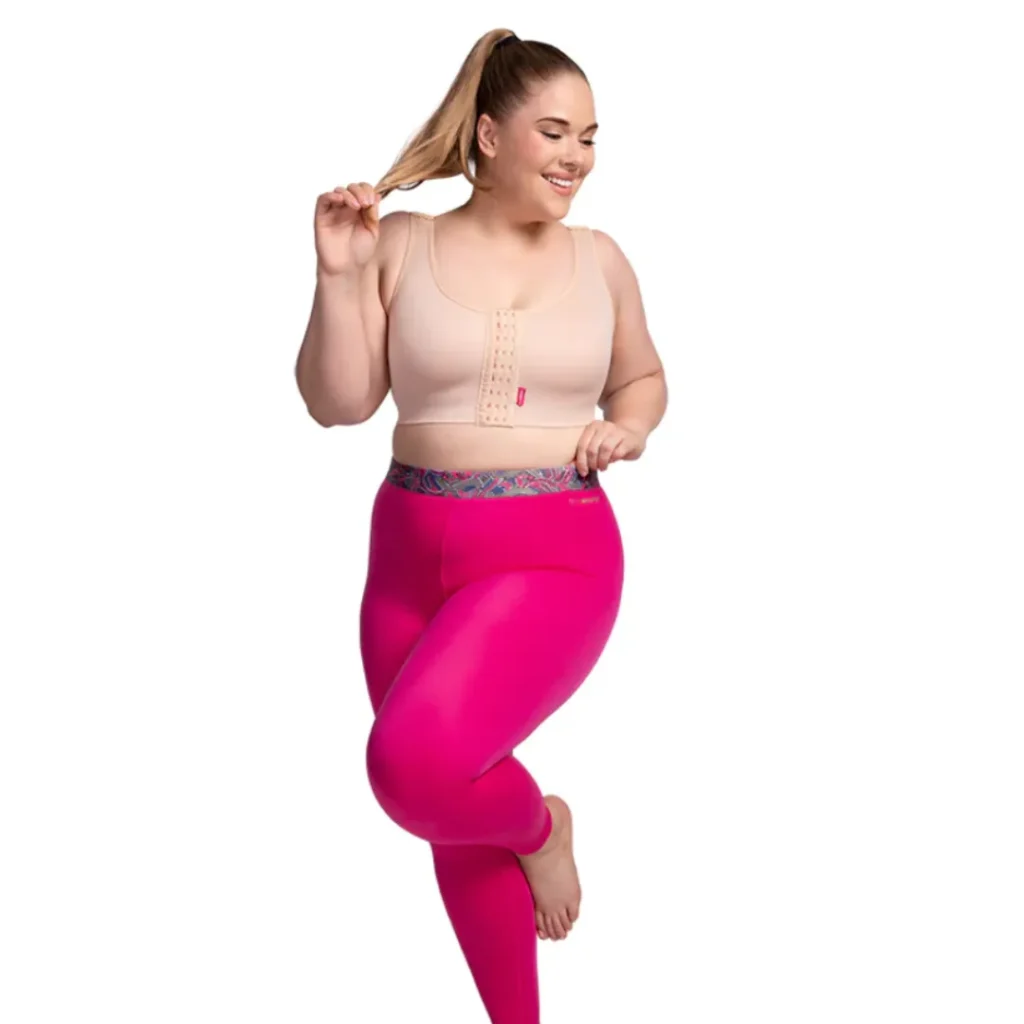 Smiling woman in pink leggings and beige front-closure bra